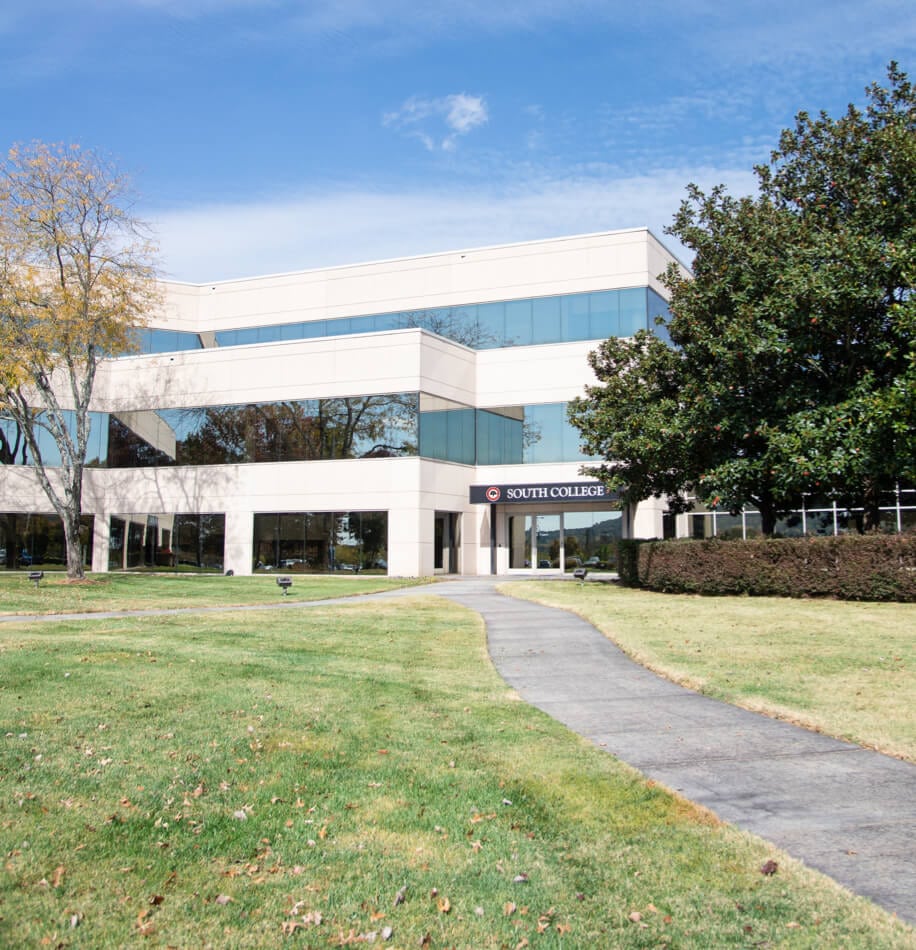 A modern, white office building with several large windows, labeled "South College."